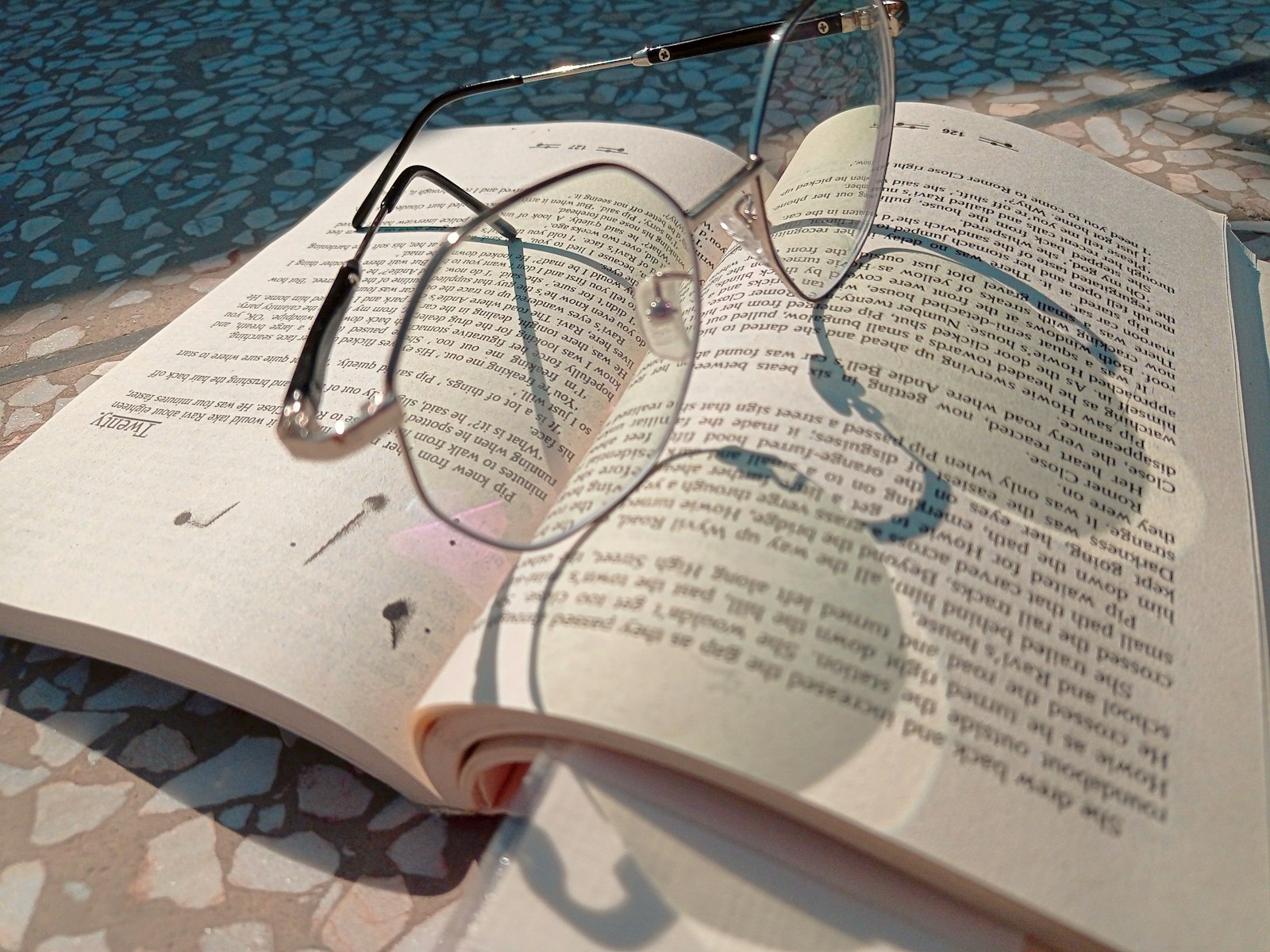 A pair of glasses resting on an open book