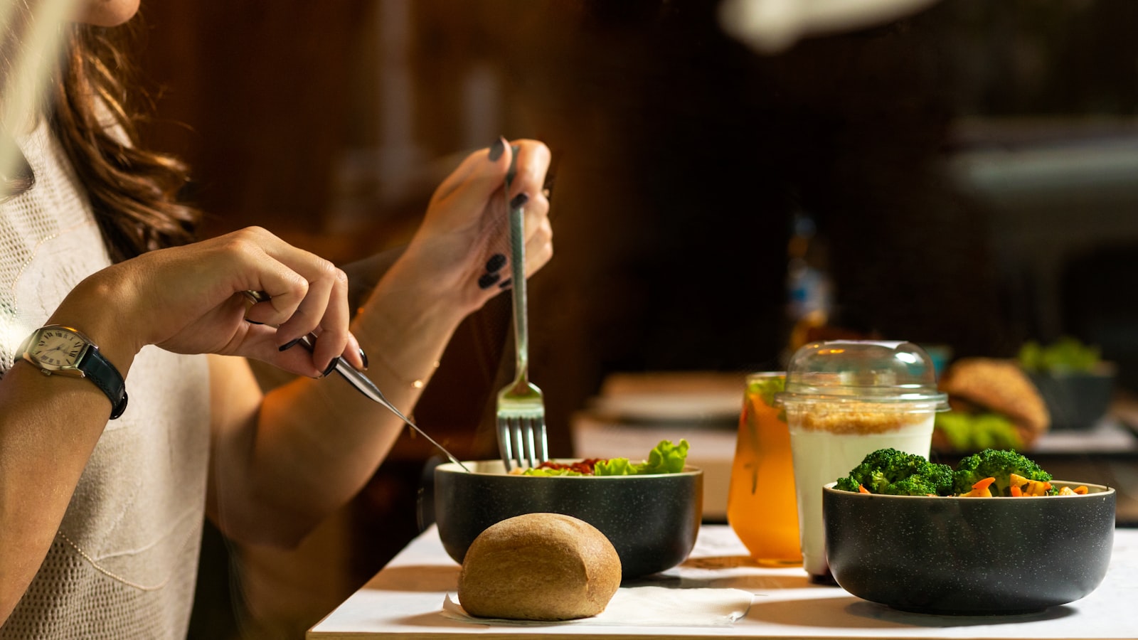 Hands eating a meal with a fork and knife