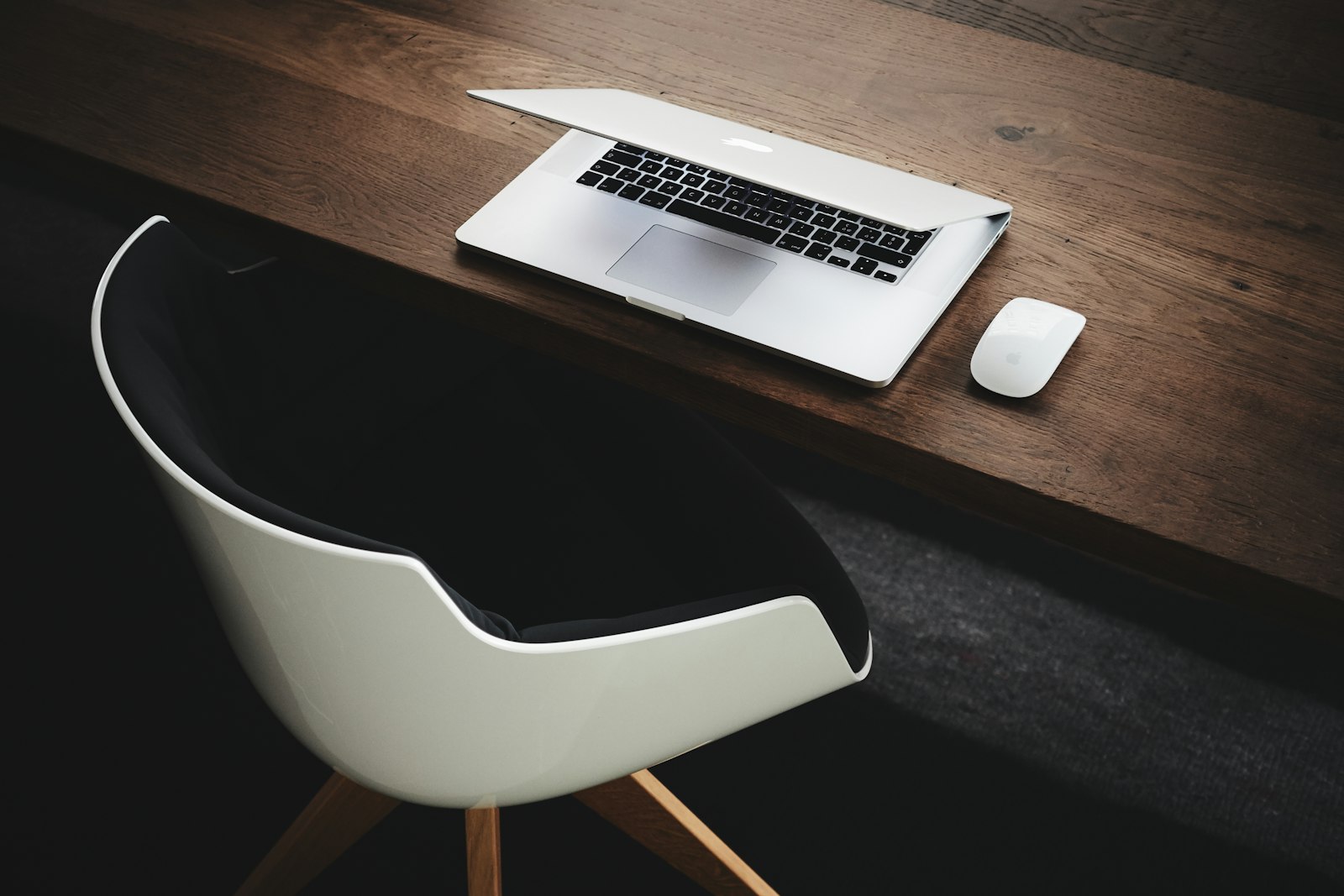 A laptop and mouse on a wooden desk